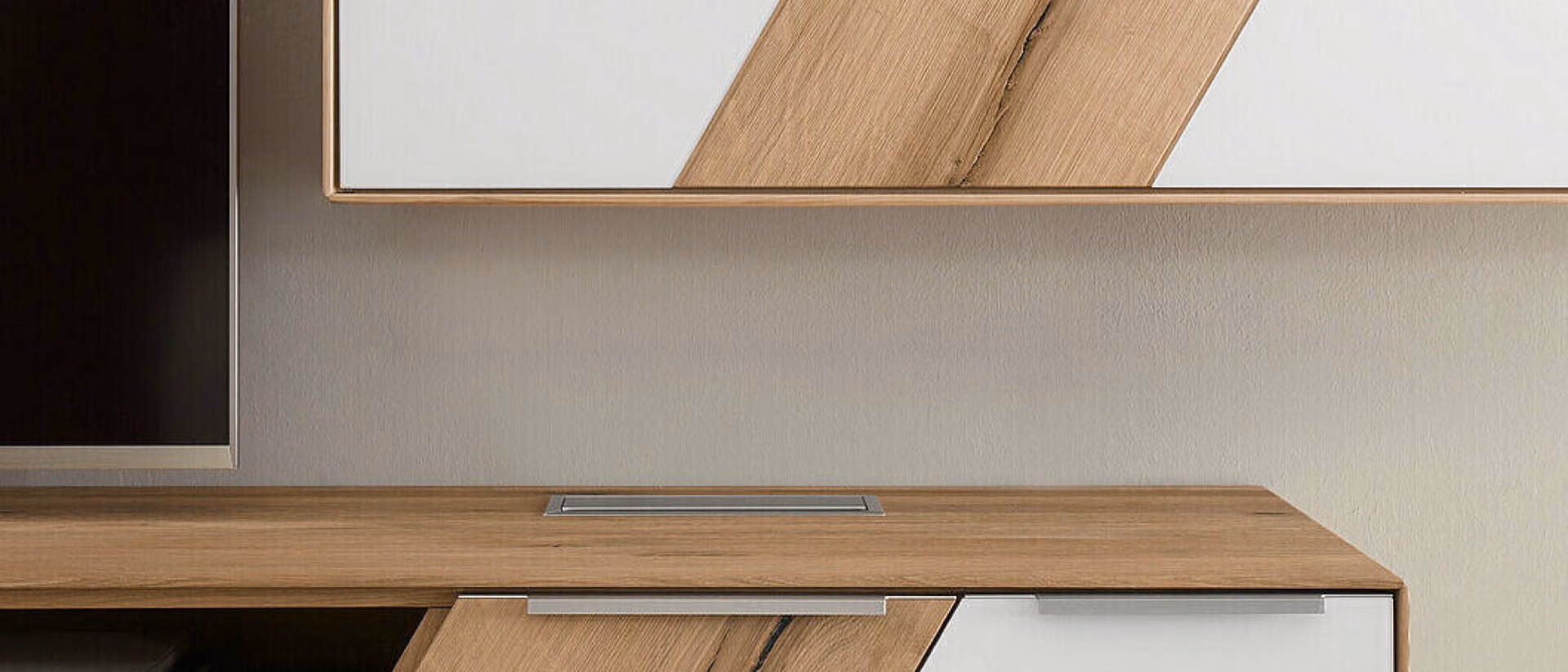 A solid wood wall unit with white fronts and a diagonal oak inlay stretches across a pale wall above a long oak sideboard.