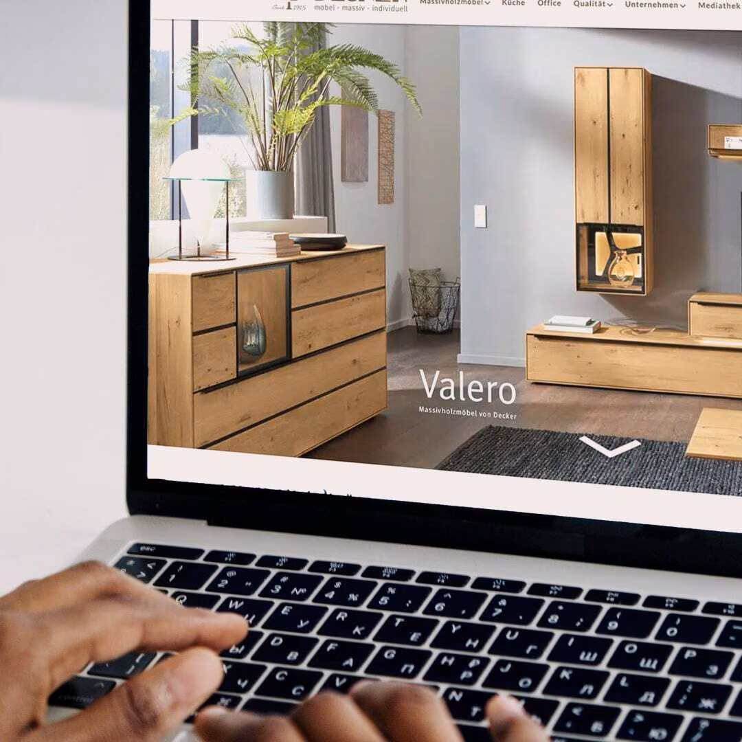Hands type on a laptop showing the Decker website and its Valero solid wood collection.