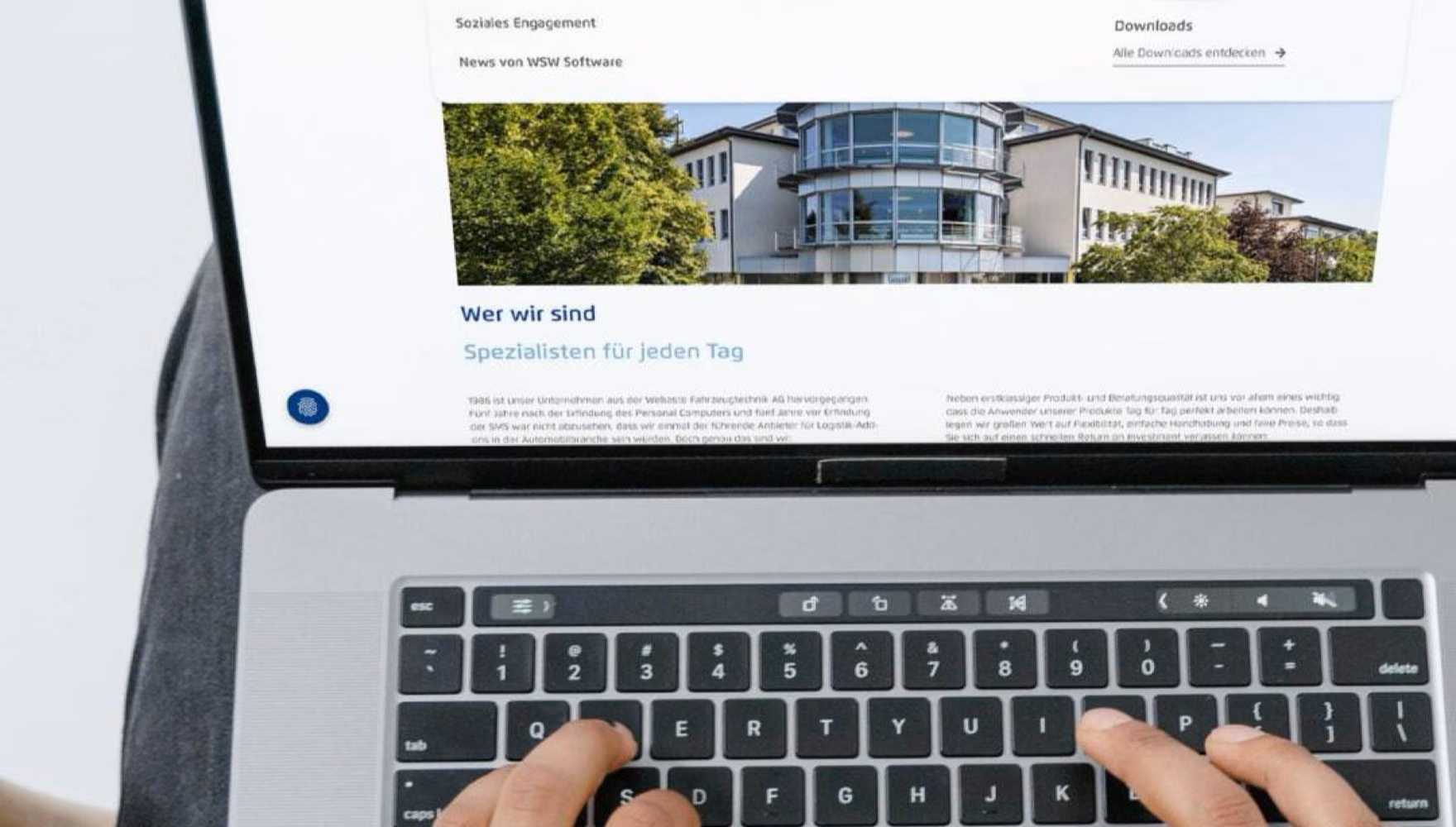 Hands type on a laptop showing the WSW Software site with its company and careers menu open.