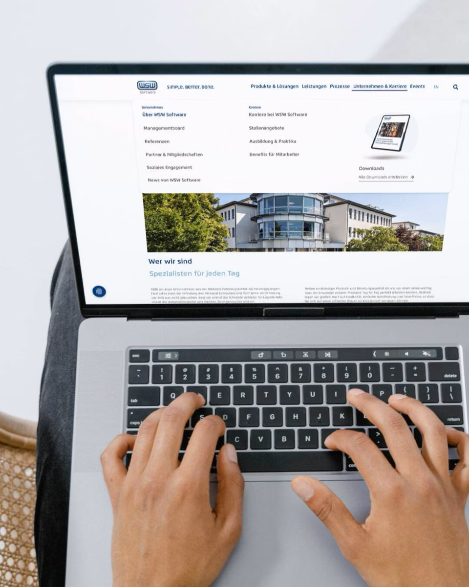 Hands type on a laptop showing the WSW Software site with its company and careers menu open.