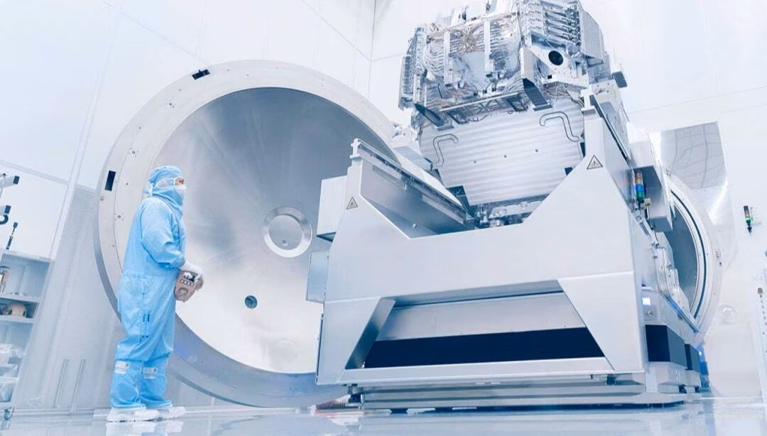 A ZEISS technician in a cleanroom beside a lithography system.