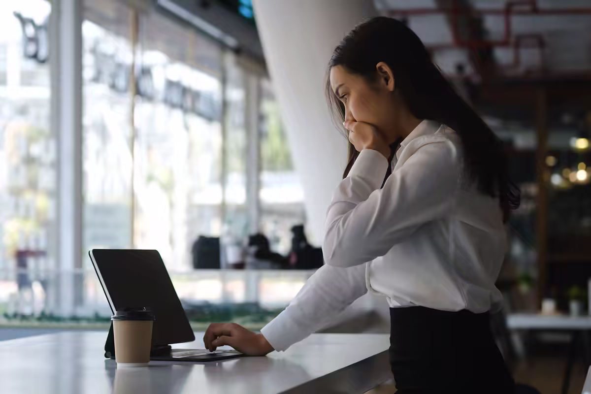Marketer reading good news at a laptop.